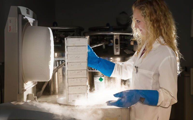 Scientist pulling research specimens from biorepository freezer